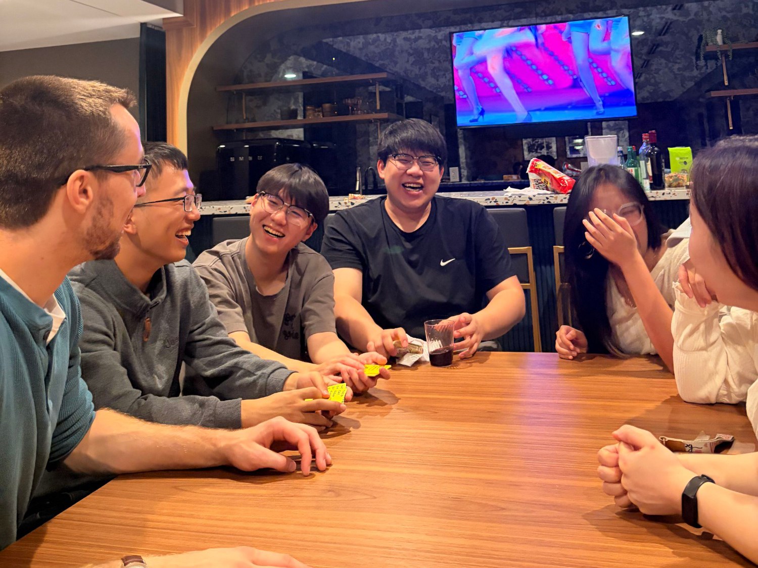 Lab members laughing over a card game at Seungyeon Jwa's farewell